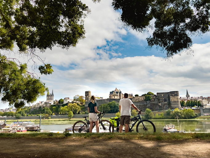 Couple qui fait du vélo devant le château d'Angers