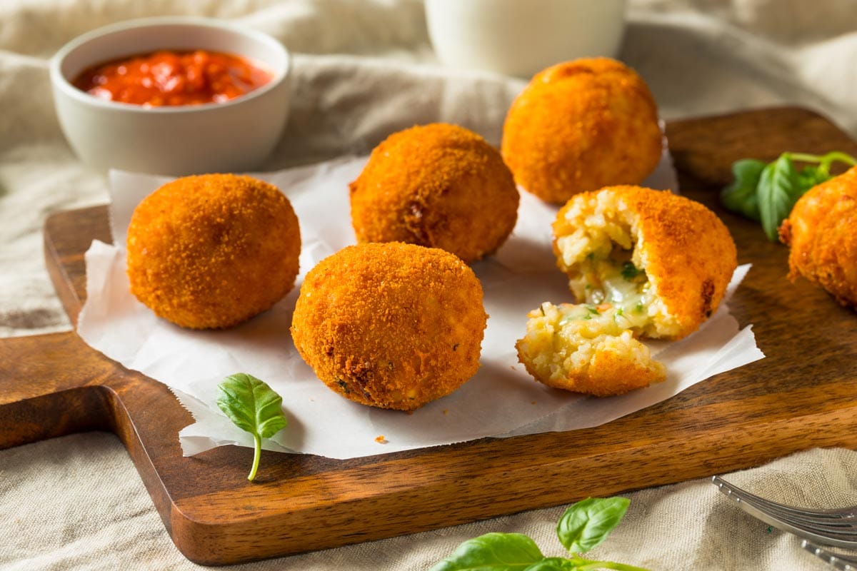 shutterstock 1353450443 ©brent hofacker homemade deep fried risotto arancini with basil and marinara